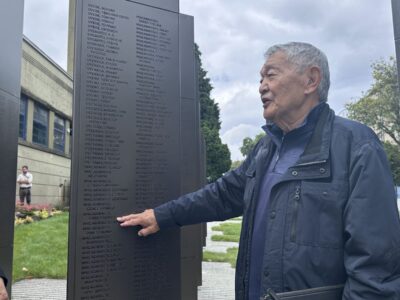 Henry Wakabayashi points to his name on the monument
