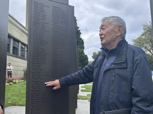 Henry Wakabayashi points to his name on the monument